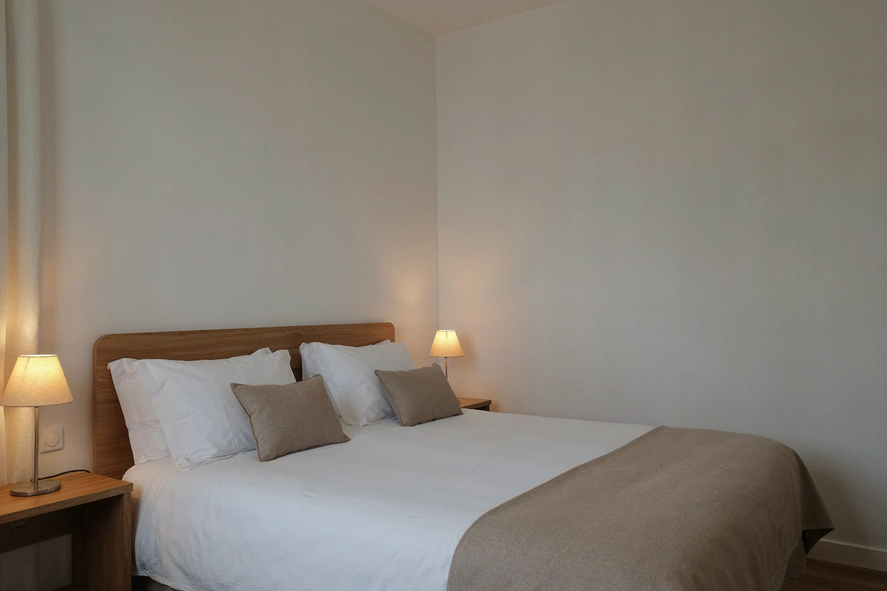 Chambre standard double, literie blanche et tête de lit en bois
